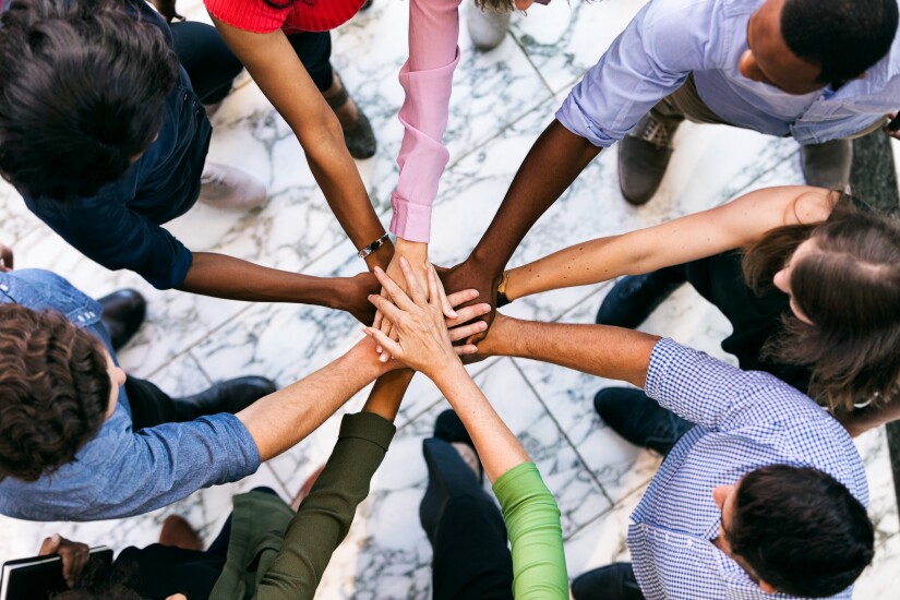 Workspace: Team Of Diverse Workers Put Hands Together